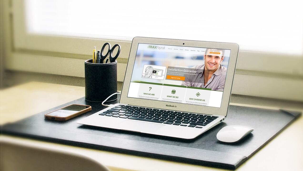 TRAXPayroll website on a laptop