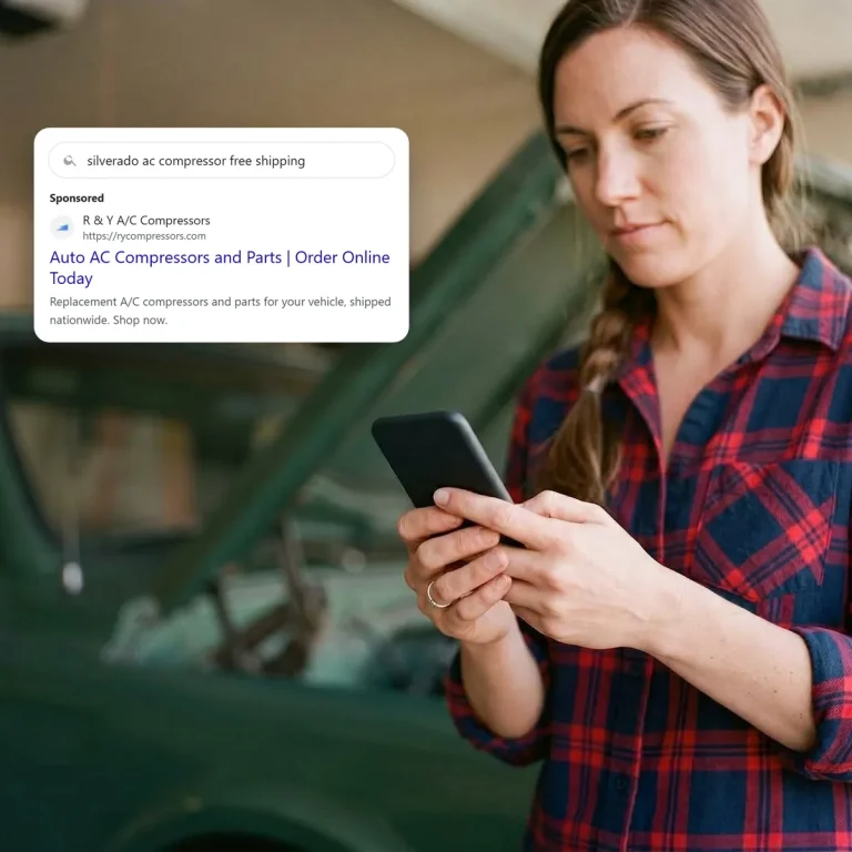 A truck owner on her phone, looking at a search ad from R & Y A/C Compressors